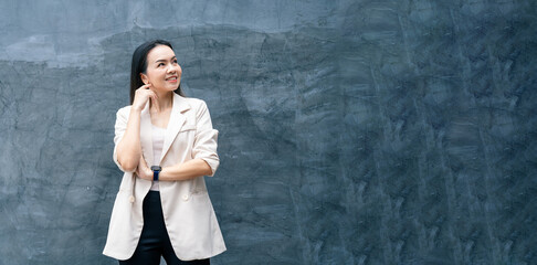 Fototapeta na wymiar Portrait of successful business asian woman in grey suit with smile isolated over blue background. Business stock photo.