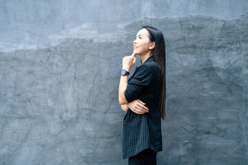 Fototapeta premium Portrait of successful business asian woman in black suit with smile isolated over blue background. Business stock photo.