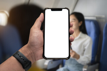 technology concept - Hand holding mobile phone with blank screen sitting in airplane.