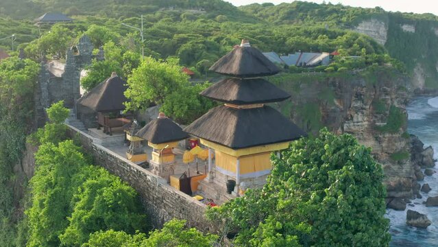 Uluwatu Temple one of six key Bali temple perched on top mountain cliff on nature background Bali, Indonesia 4K Aerial view