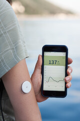 The women reads the glucose values from the Abbott Freestyle Libre sensor using an application on...