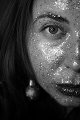 Close-up portrait of a beautiful girl with festive make-up. Perfect red lip design. Gold and glitter shines on her face. Christmas festive make-up. New Year, Christmas, birthday.