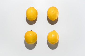 Fresh lemons on white background. Hard light isolated for pattern. Hard light top view. Fresh food and vitamin C in nutrition and skincare