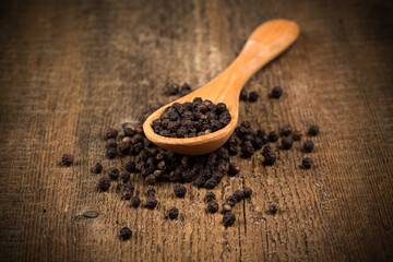 black pepper on wooden spoon