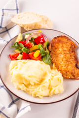 Fried chicken steak or schnitzel with mashed potatoes and vegetables salad in plate