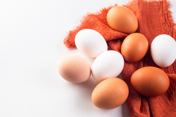 Chicken eggs on linen napkin on white background.