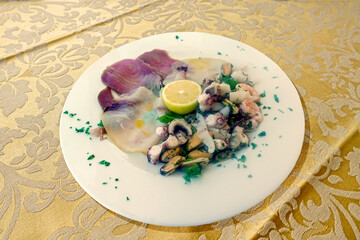 Frutti di mare in un piatto bianco su una tovaglia gialla 9176