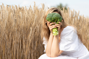 Brokkoli Gem&uuml;se zur Erntezeit von Frau in der Hand gehalten