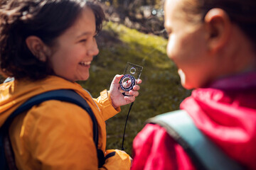 Young hikers using a compass to navigate through the forest