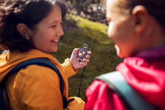 Young hikers using a compass to navigate through the forest