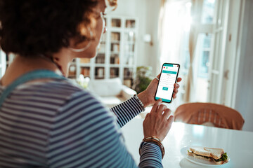 Young woman using a health app on her smartphone at home