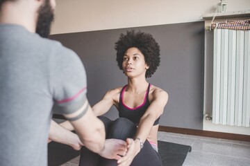 Obraz premium Multiethnic couple at home practicing sport doing fitness yoga