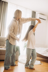 Mom and her daughter child girl are dancing. Family holiday and togetherness.