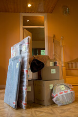 A pile of packed boxes and other items marked as fragile; ready for moving or unpacking in the hallway of a house