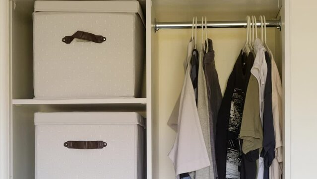 Filling and arrangement of clothes in the home closet, stop motion. Putting things in order and hanging men's clothes, animation