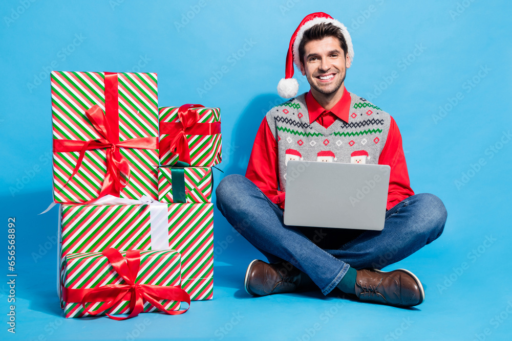 Sticker Full body photo of cute young man eshopping netbook presents dressed x-mas print vest hat clothes isolated on blue color background