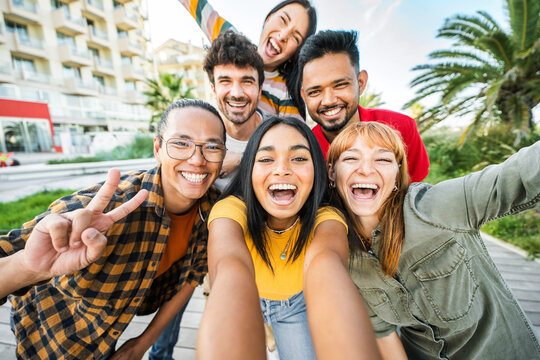 Multiracial friends taking selfie pic with smart mobile phone outside - Happy young people having fun talking on city street - Life style concept with guys and girls hanging out on a sunny day