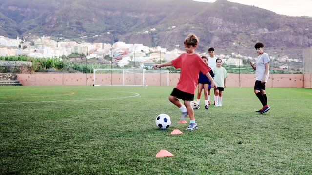 Sport soccer kids training slalom drill for agility practice - Football players run with ball between cones