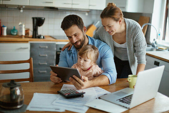Young family using the tablet together in the kitchen