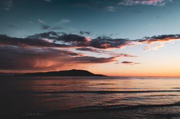 Dramatic sunset on open sea with island in the distance. Scotland north-coast 500