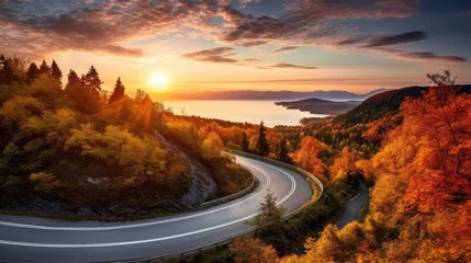 Poster Curved road on autumn, beautiful curved pass with vehicles and colorful autumn nature colors on trees with sunset light © Sasint