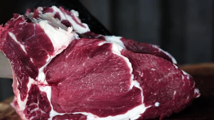 Farmer butcher cutting fresh organic meat piece on slice use knife for cooking food closeup