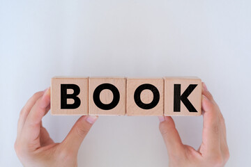 Man hands holding wooden cubes with Book text on it, reading or education idea, wooden block cubes with Book word, wood blocks on white background, togetherness concept banner