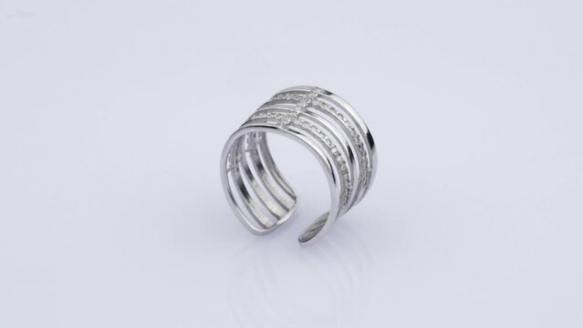 Rotating silver ring with reflection on white background. Video rotation 360.