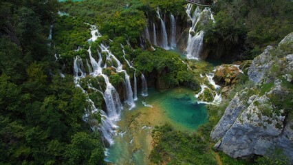 Waterfall in green mountain forest, aerial top down view. Summer landscape. Famous landmark and tourist attraction.