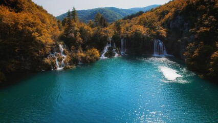 Autumn nature in Plitvice Lakes National Park Croatia. Aerial view of waterfall flows into emerald green fresh water at sunset.