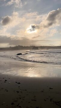 Sunset on Penarronda beach, Castropol, Asturias. Landscape of beach and coast on a grey day. Vertical video.