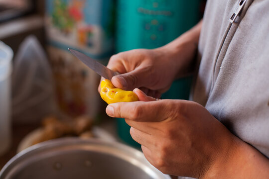 Photo of hands peeling Olluco. Concept of food and traditions in Peru.