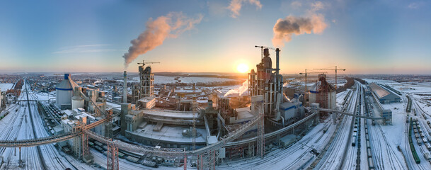 Aerial view of cement factory with high concrete plant structure and tower crane at industrial...