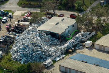 Aerial view of large pile of scrap aluminum metal from broken houses after hurricane Ian swept through Florida. Recycle of broken parts of mobile homes