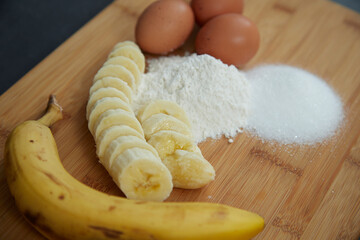close-up of ingredients for a cake, banana, eggs, flour, sugar on a board