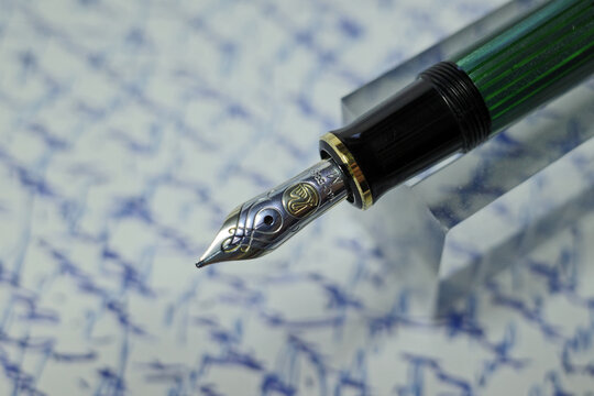 Itterbeck, Germany Oct 3 2023 Pelikan Souveraen M600 Fountain Pen. A blurred handwritten text in the background.