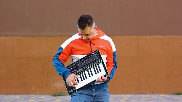 Guy playing wireless synthesizer close-up