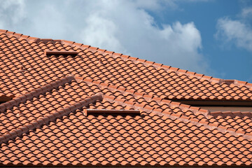 House rooftop covered with yellow ceramic shingles. Tiled covering of residential apartment building