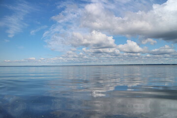 white blue seascape, smooth sea, cumulus clouds, beautiful nature