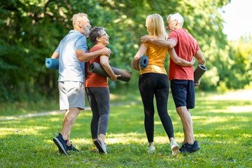Active Retirement. Two Senior Couples Training Together In Park Outdoors