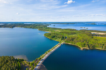 Road leading through the finnish lake district, seen from the air on a beautiful summer day - obrazy, fototapety, plakaty