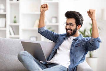 Happy Excited Indian Man Celebrating Success While Using Laptop At Home
