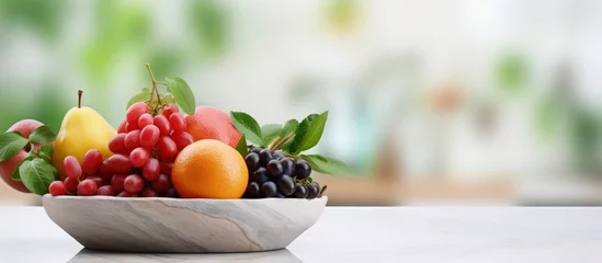 Gartenposter Fruit basket and copy space on marble desk with blurred kitchen background with copyspace for text © 2rogan