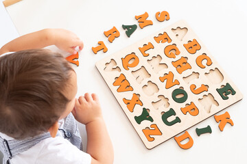 Bird eye view of preschooler, kindergarten boy playing with alphabet blocks