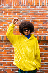 fashionable afro mexican man with cool attitude is pointing copy space in vertical