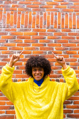 A fashionable smiling man afro mexican is pointing copy space in vertical