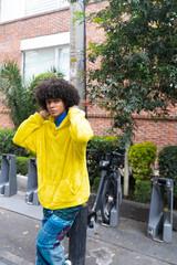 man afro mexican adjust the cap of his sweatshirt looking at the camera in the bicycle parking lot in Mexico City