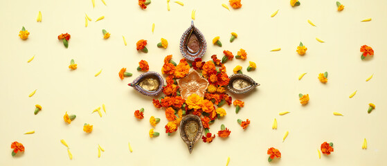 Diya lamps and marigold flowers on beige background. Celebration of Divaly (Indian Festival of Lights)