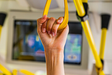 people holding onto a handle on a train © Evgeniya