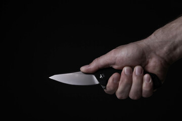A sharp knife in the man's hand. The use of cold weapons. Knife attack . Armed raid.